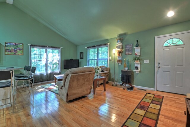 living room featuring light hardwood / wood-style flooring and high vaulted ceiling