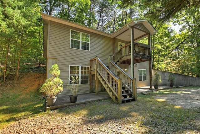 back of property featuring a wooden deck and a patio