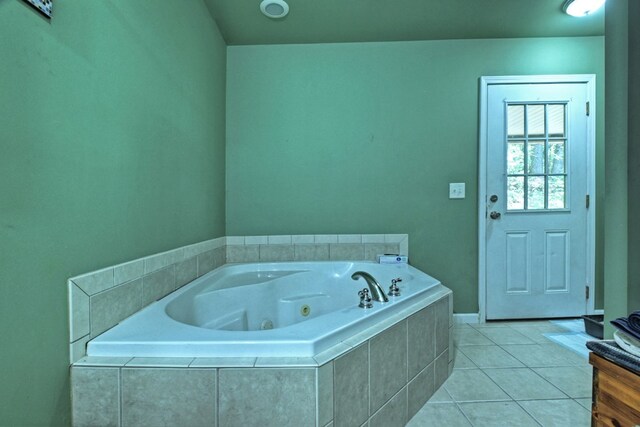 bathroom with tiled bath and tile patterned floors