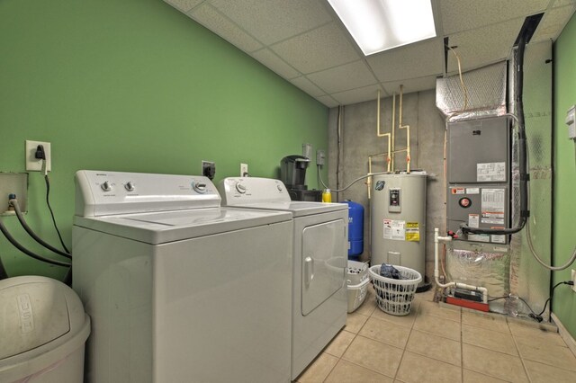 clothes washing area with light tile patterned floors, washer and dryer, and electric water heater