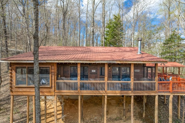 rear view of property featuring a deck and metal roof