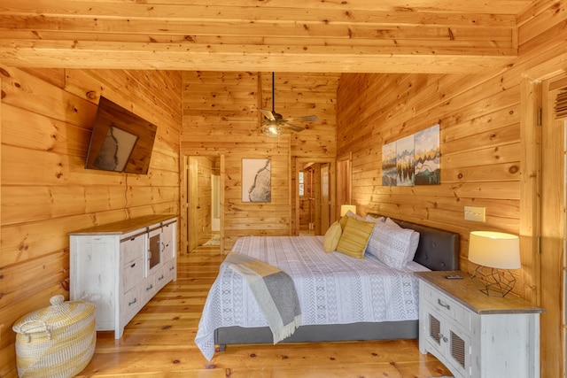 bedroom with wood walls and light wood finished floors