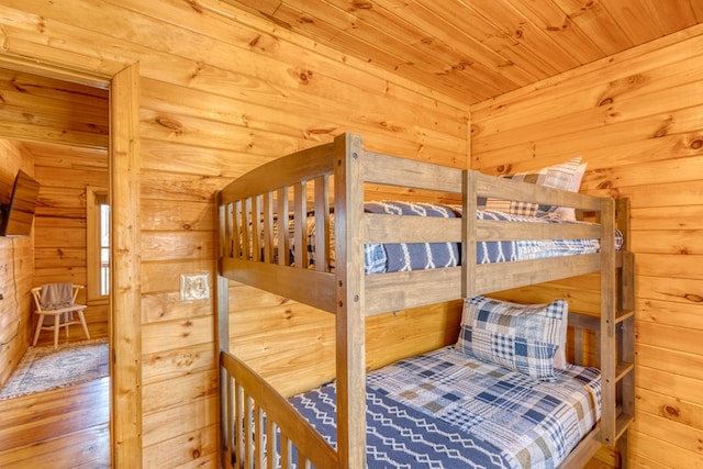 bedroom featuring wood ceiling, wood finished floors, and wooden walls