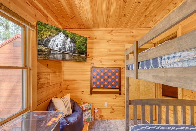 bedroom with wooden walls, wooden ceiling, and wood finished floors