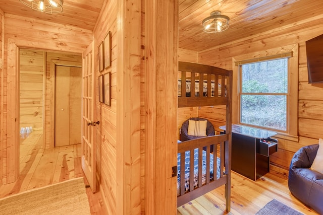 bedroom with wood-type flooring, wood walls, and wooden ceiling