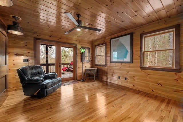 unfurnished room featuring light hardwood / wood-style floors, plenty of natural light, and wooden walls