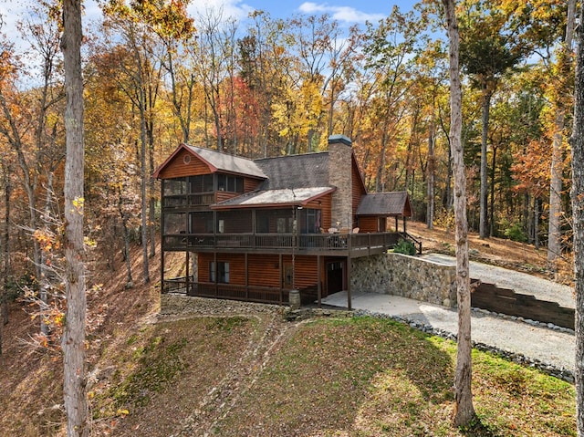 back of house featuring a patio, a deck, and a sunroom