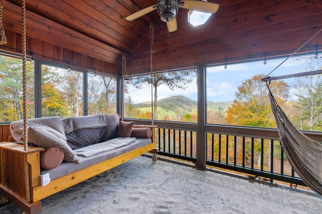 sunroom / solarium with a mountain view, ceiling fan, a healthy amount of sunlight, and vaulted ceiling