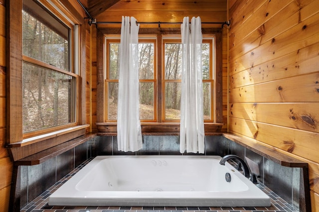 bathroom featuring tiled tub and wooden walls