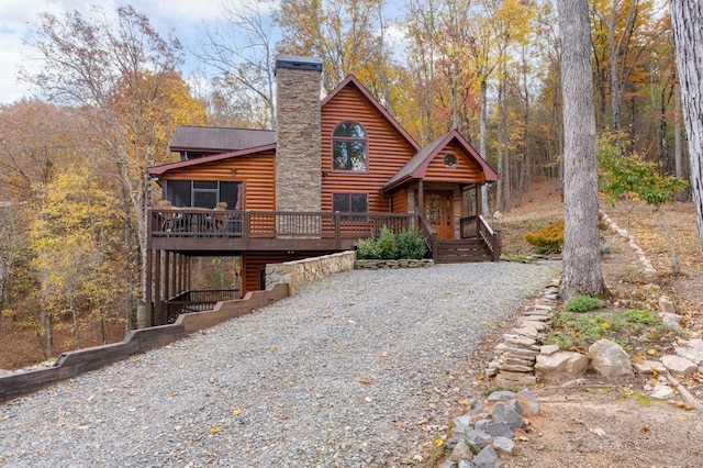 log cabin featuring a sunroom and a wooden deck