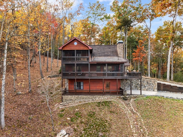 rear view of house with a wooden deck and a sunroom