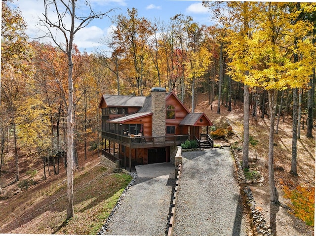 view of front of property featuring a sunroom, a deck, and a garage