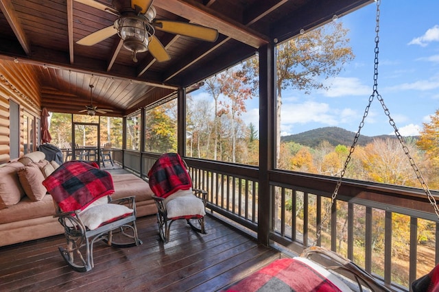 sunroom featuring a mountain view, ceiling fan, wooden ceiling, and vaulted ceiling