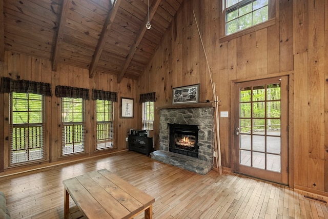 unfurnished living room with visible vents, wood-type flooring, beam ceiling, high vaulted ceiling, and wood ceiling