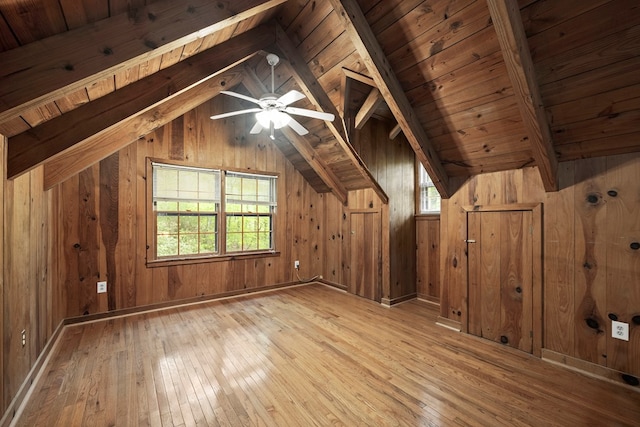 bonus room with ceiling fan, wooden ceiling, wooden walls, vaulted ceiling with beams, and hardwood / wood-style floors