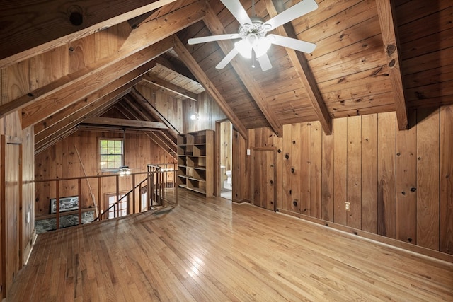 bonus room featuring wood walls, vaulted ceiling with beams, hardwood / wood-style flooring, wooden ceiling, and a ceiling fan