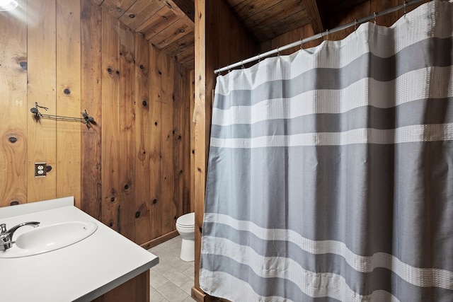 bathroom with wooden walls, wood ceiling, vanity, and toilet
