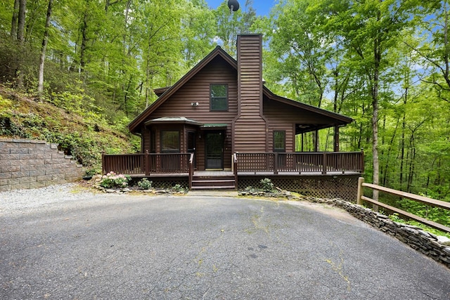 rustic home featuring a chimney and a deck