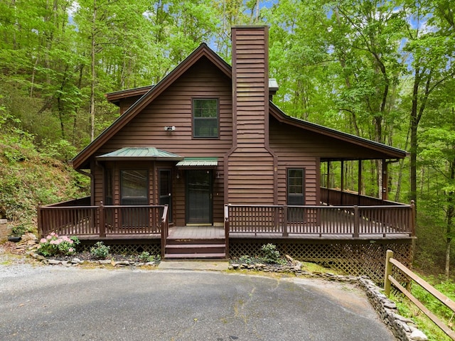 chalet / cabin with a deck and a chimney