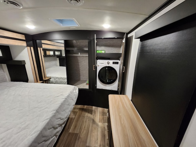 washroom featuring visible vents, laundry area, wood finished floors, and washer / dryer