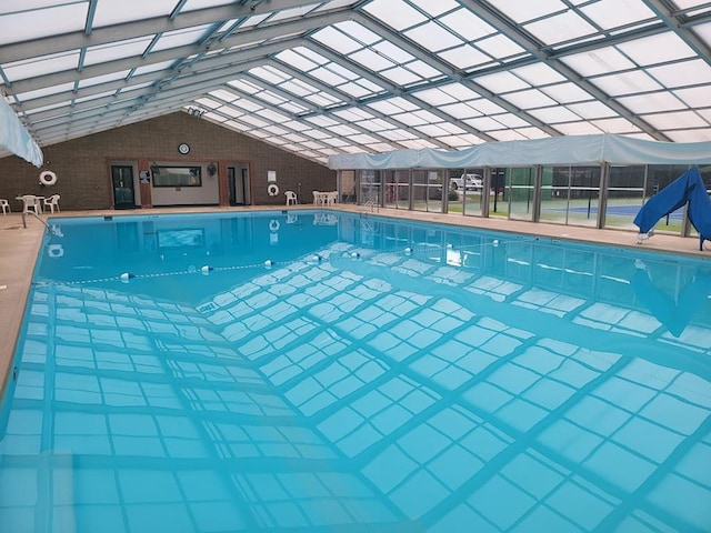 community pool with glass enclosure and a patio