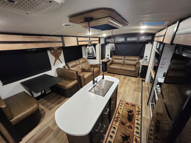 home theater featuring light wood-type flooring and a sink