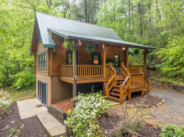 121 Farmstead Rd, Ellijay, GA 30540 - view of front of home with covered porch, metal roof, a garage, a view of trees, and stairs