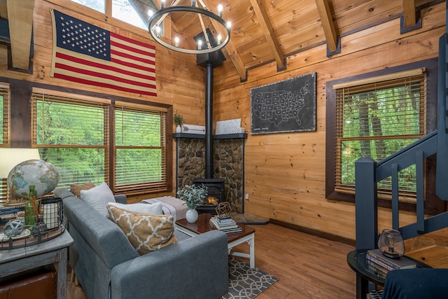 121 Farmstead Rd, Ellijay, GA 30540 - living room featuring an inviting chandelier, vaulted ceiling with beams, a wood stove, and wooden walls