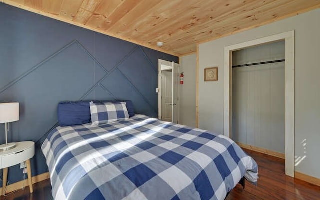 bedroom featuring a closet, dark hardwood / wood-style flooring, and wood ceiling