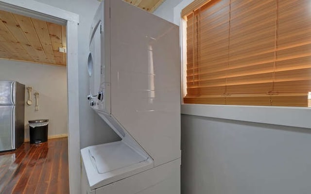 laundry area featuring stacked washer and dryer, wood ceiling, and hardwood / wood-style flooring