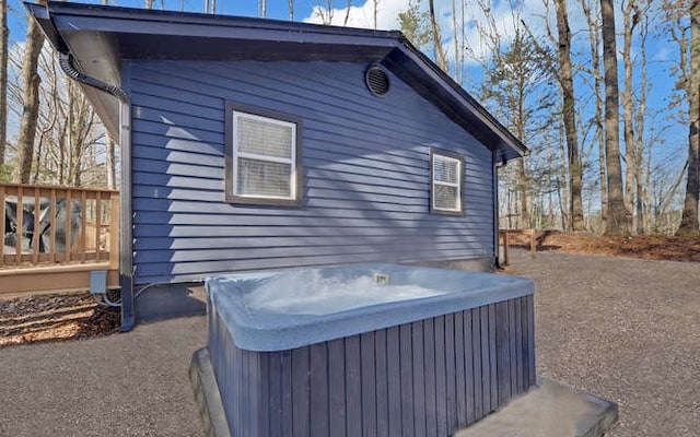 view of home's exterior featuring a hot tub and a deck