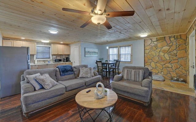 living room with dark wood-type flooring, wood ceiling, and ceiling fan