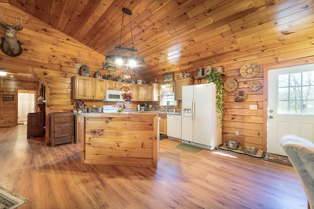 kitchen featuring wooden walls, a center island, white appliances, light hardwood / wood-style floors, and hanging light fixtures