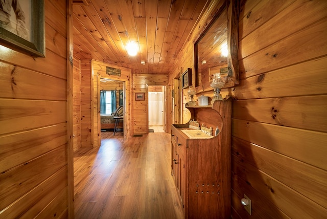 hallway with wood walls, wood ceiling, and wood-type flooring