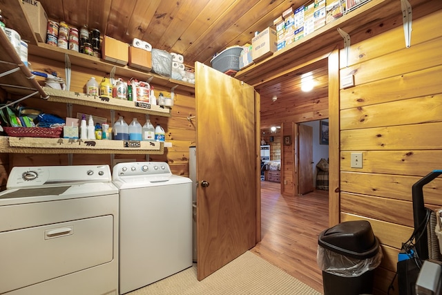 laundry room with light hardwood / wood-style flooring, wood walls, independent washer and dryer, and wooden ceiling