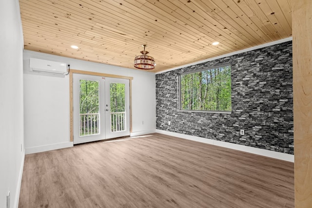 spare room with wood ceiling, french doors, wood finished floors, and a wall mounted AC