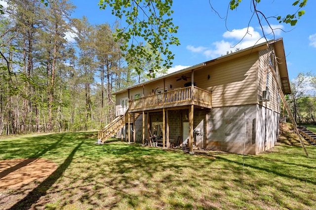 back of property with a ceiling fan, a lawn, stairway, and a deck