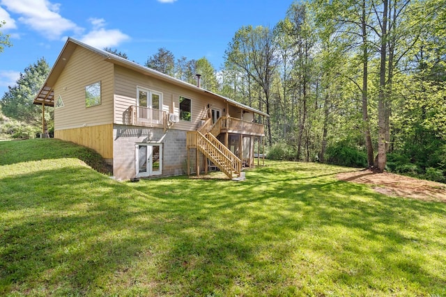 back of property with a wooden deck, a yard, french doors, and stairway