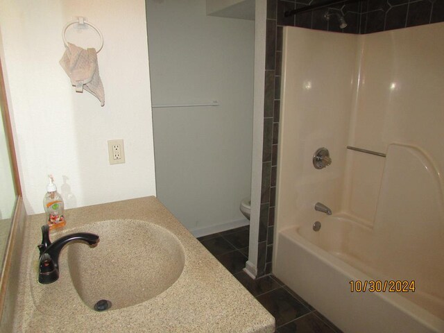 full bathroom with tiled shower / bath, sink, toilet, and tile patterned flooring