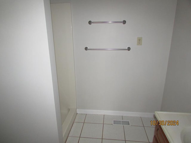 bathroom featuring vanity, walk in shower, and tile patterned flooring