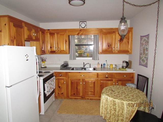 kitchen featuring white appliances, light tile patterned floors, sink, and hanging light fixtures