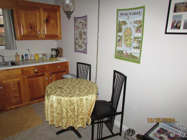 dining space featuring sink and light tile patterned floors