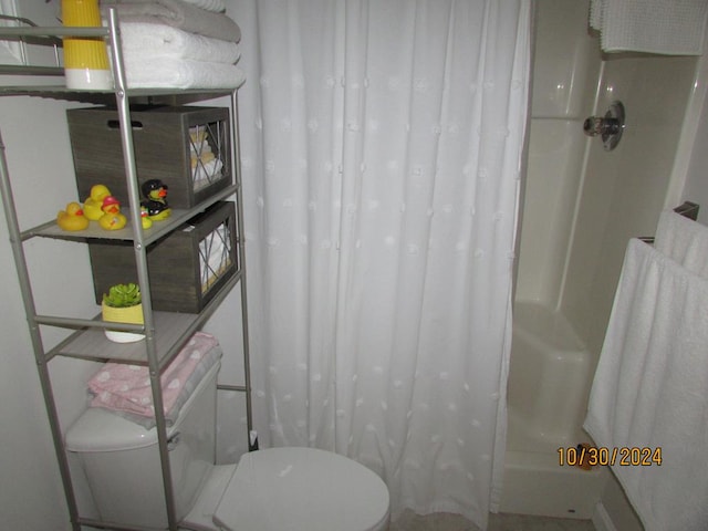 bathroom featuring toilet and shower / tub combo with curtain