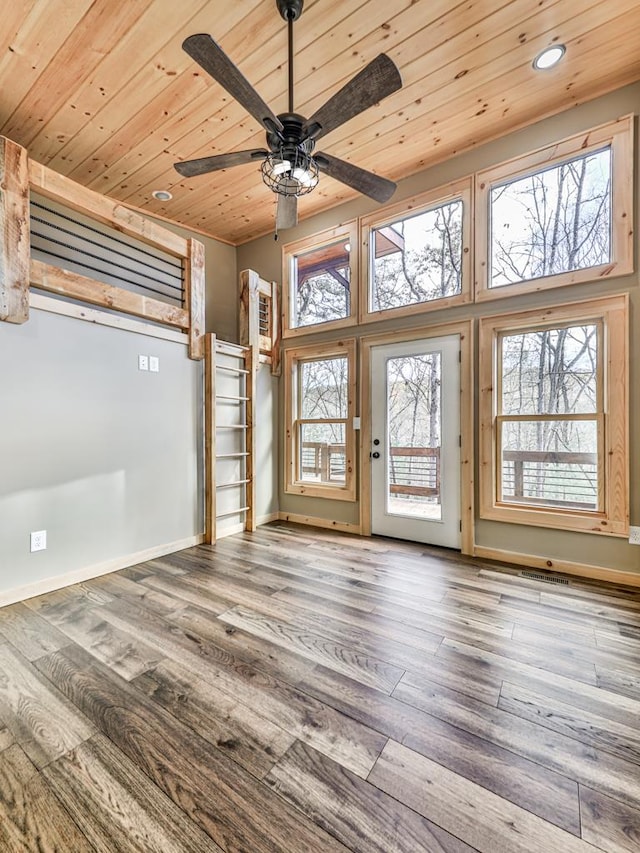 unfurnished room with hardwood / wood-style floors, a towering ceiling, ceiling fan, and wood ceiling
