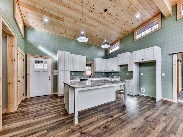 kitchen featuring stone countertops, high vaulted ceiling, white cabinetry, dark hardwood / wood-style floors, and a kitchen island
