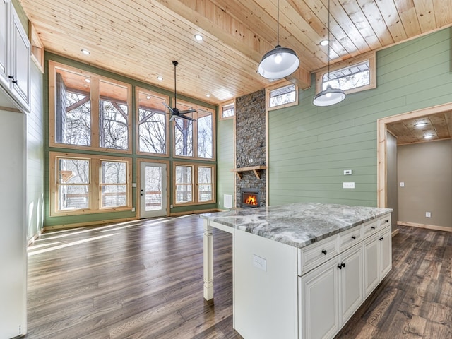 kitchen featuring white cabinets, wooden ceiling, and decorative light fixtures