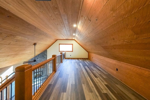 bonus room with wooden ceiling, wooden walls, vaulted ceiling, ceiling fan, and dark hardwood / wood-style flooring