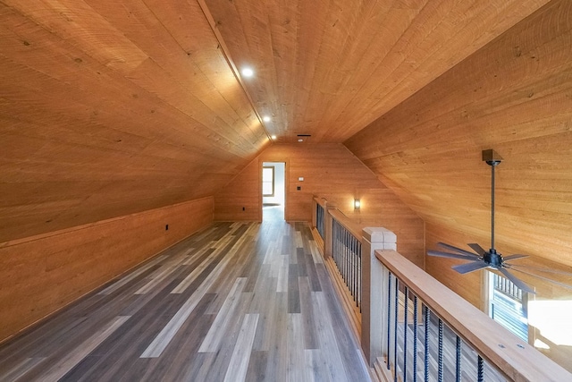 additional living space with wood walls, dark hardwood / wood-style floors, lofted ceiling, and wood ceiling