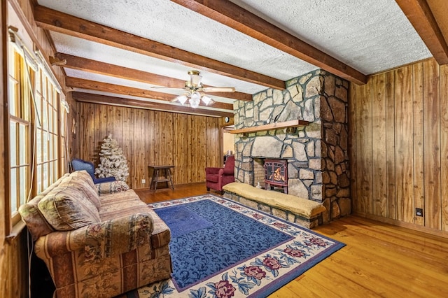 sitting room featuring a textured ceiling, ceiling fan, hardwood / wood-style floors, and beam ceiling