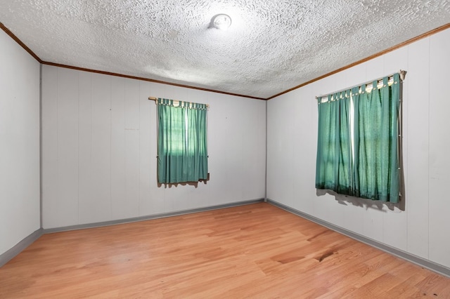 spare room featuring hardwood / wood-style flooring, a textured ceiling, and ornamental molding